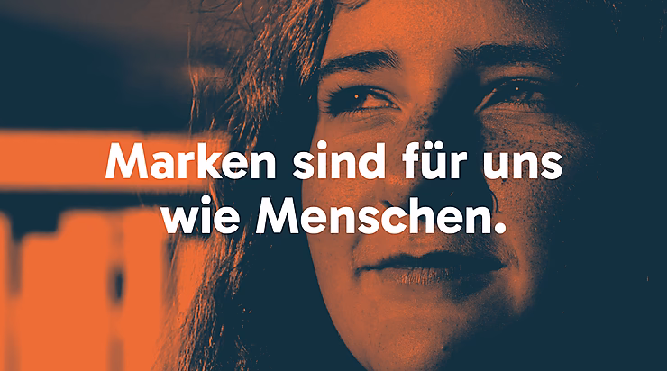 Text in orange auf dunkelblauem Hintergrund: "Marken sind für uns wie Menschen." Das Bild zeigt das Gesicht einer Person.